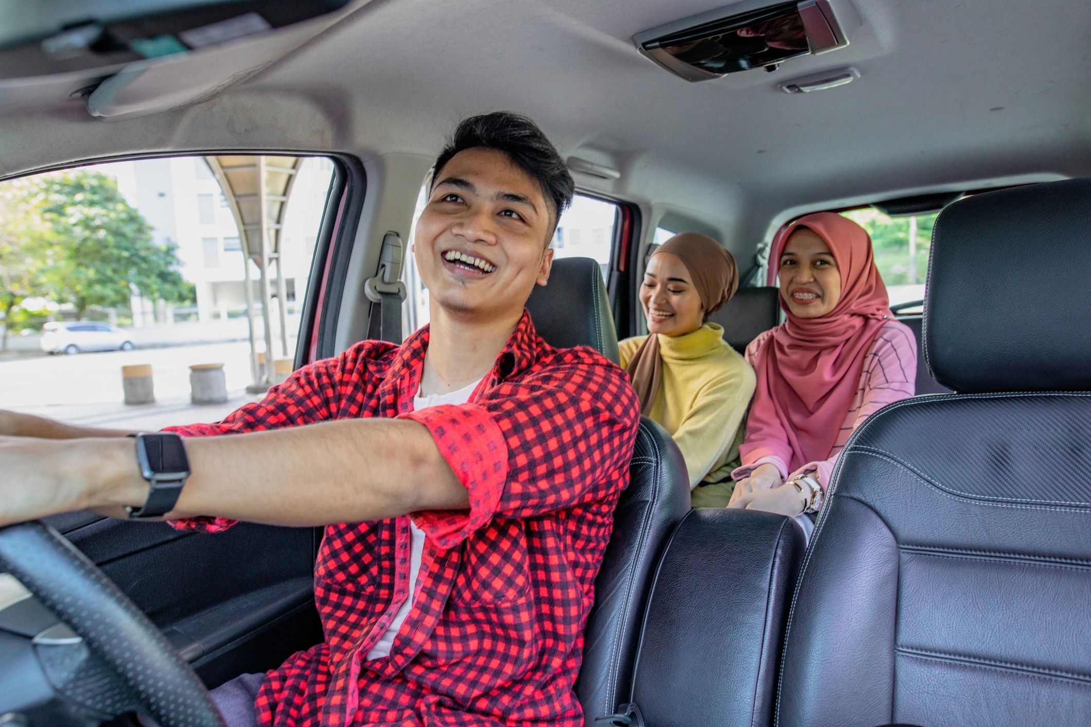 Friends smiling inside a car
